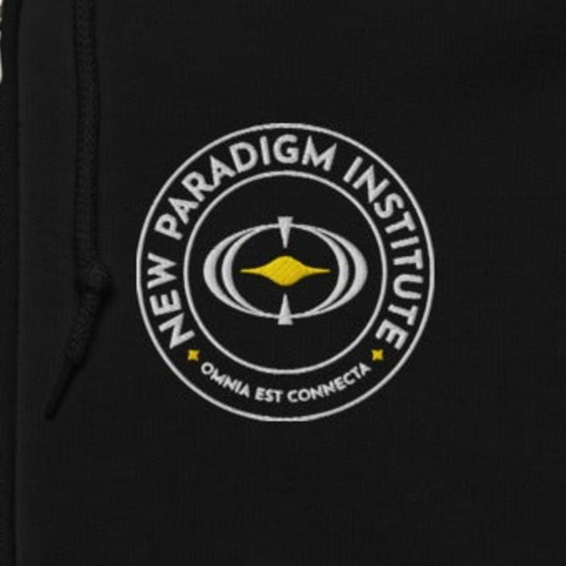 Close-up of the white and gold embroidered NPI logo on the left chest